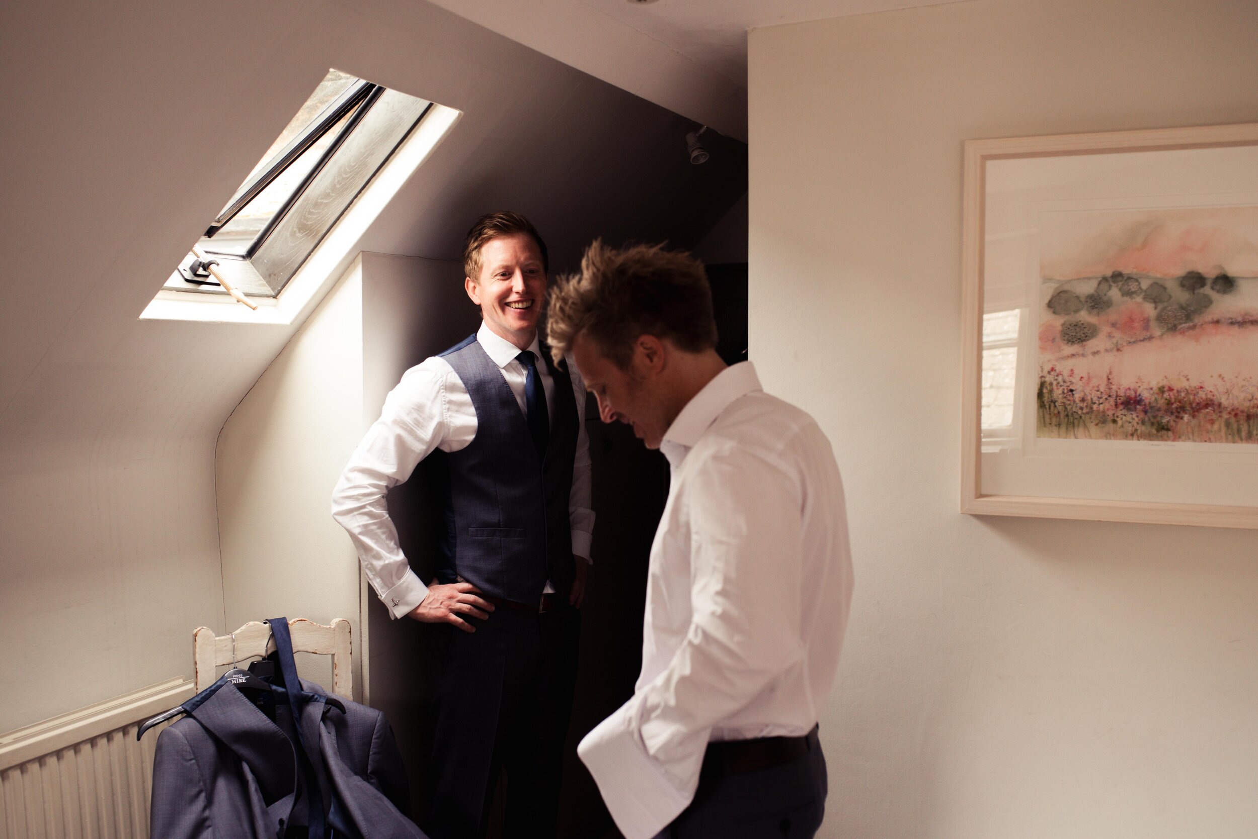 Best man and the groom getting ready by a skylight