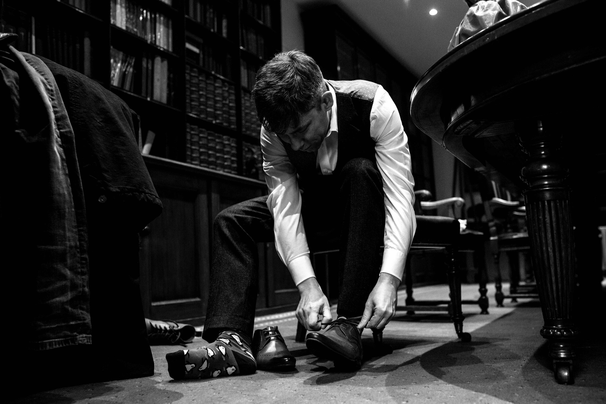 Groom putting on his wedding shoes