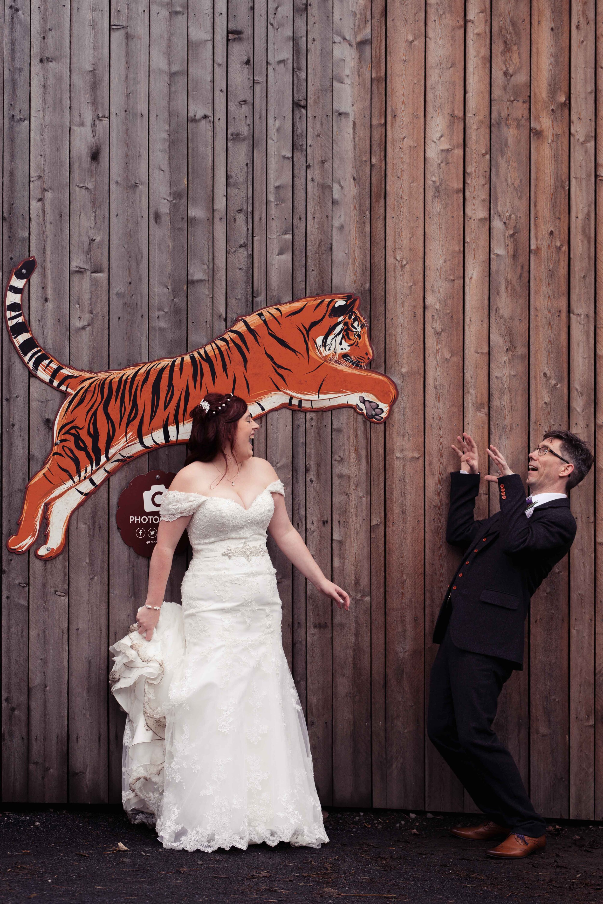 Bride and groom stand in a photo point at Edinburgh Zoo