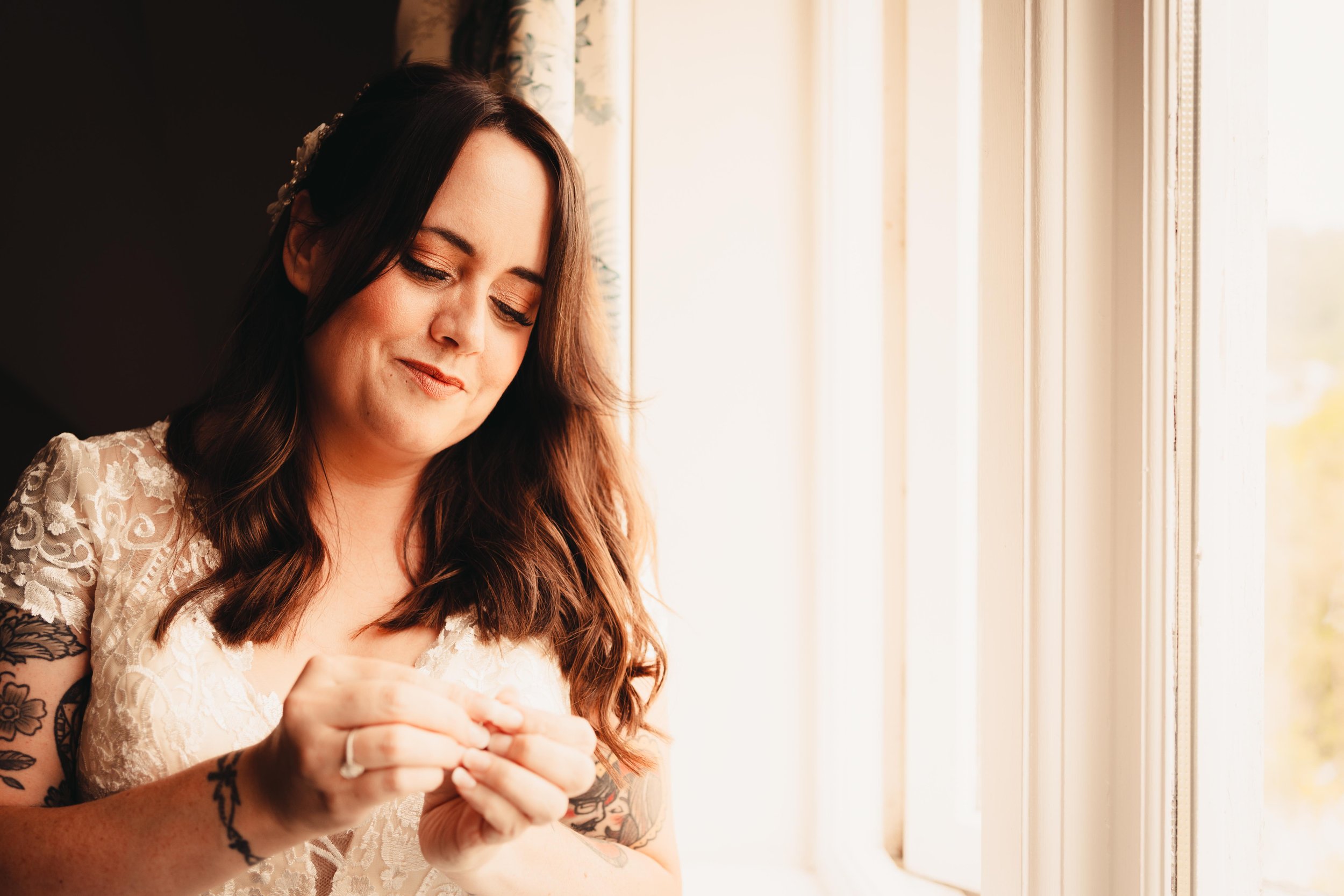 Lindeth Howe bride putting her makeup on in the bedroom window