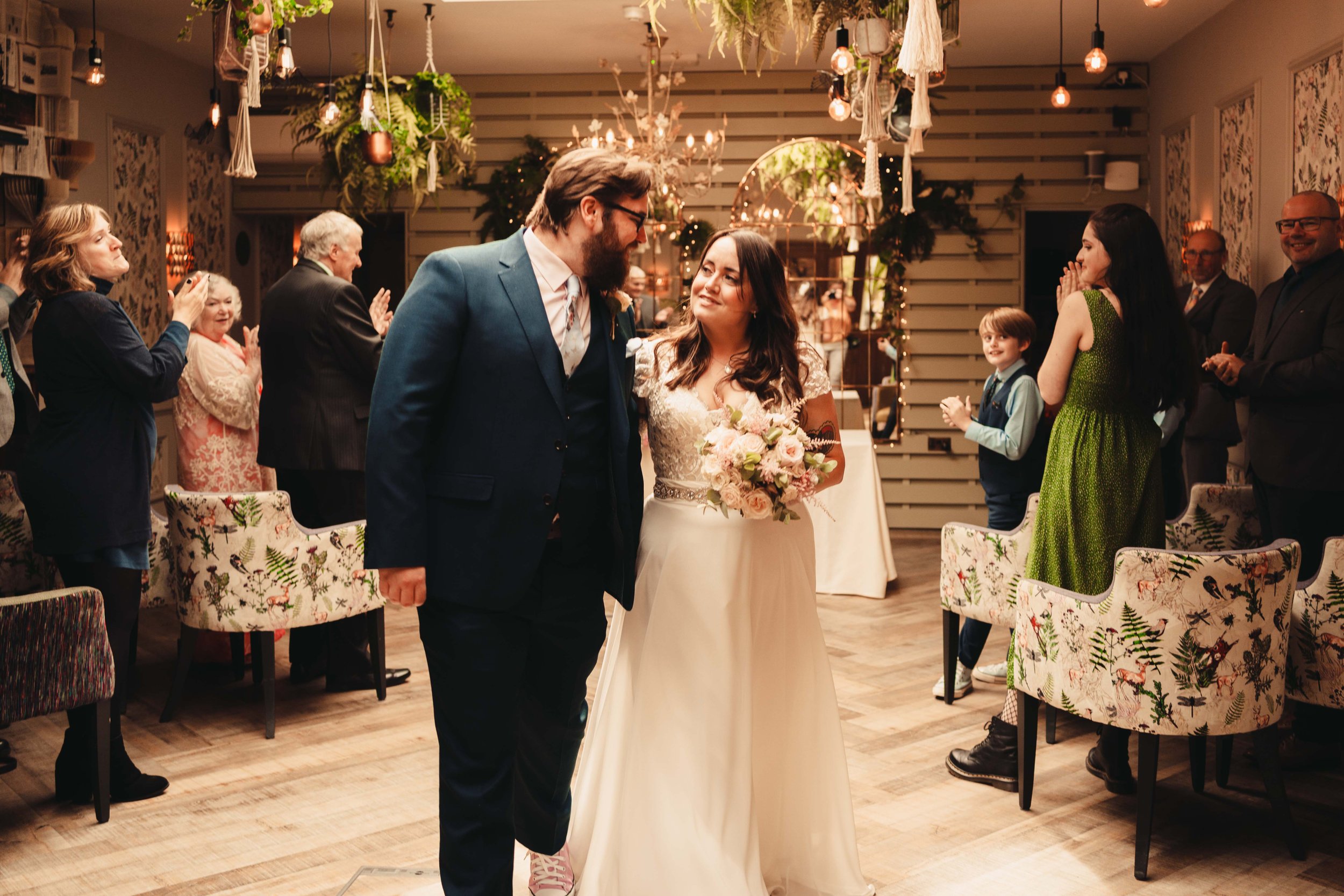 Bride and groom walking out of the wedding ceremony at Lindeth Howe