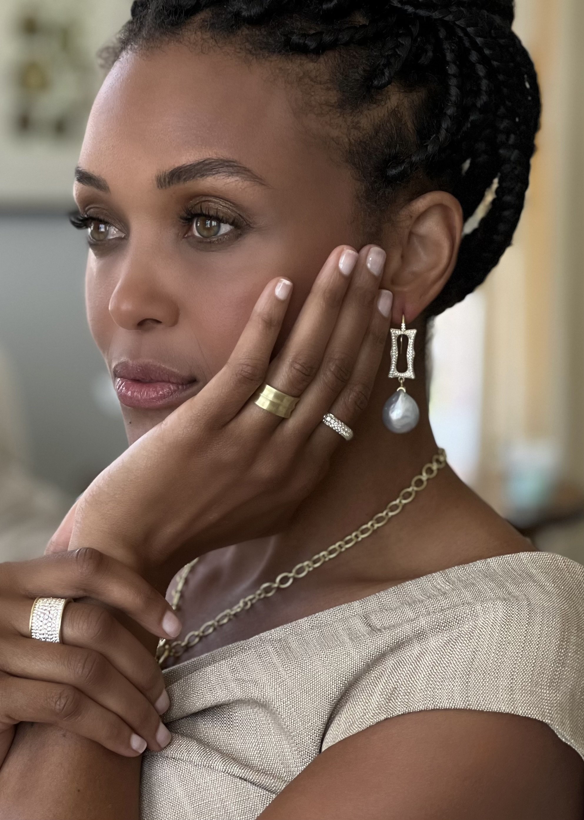 Model wearing Leigh Maxwell earrings with diamond pavé frame and white baroque South Seas pearls