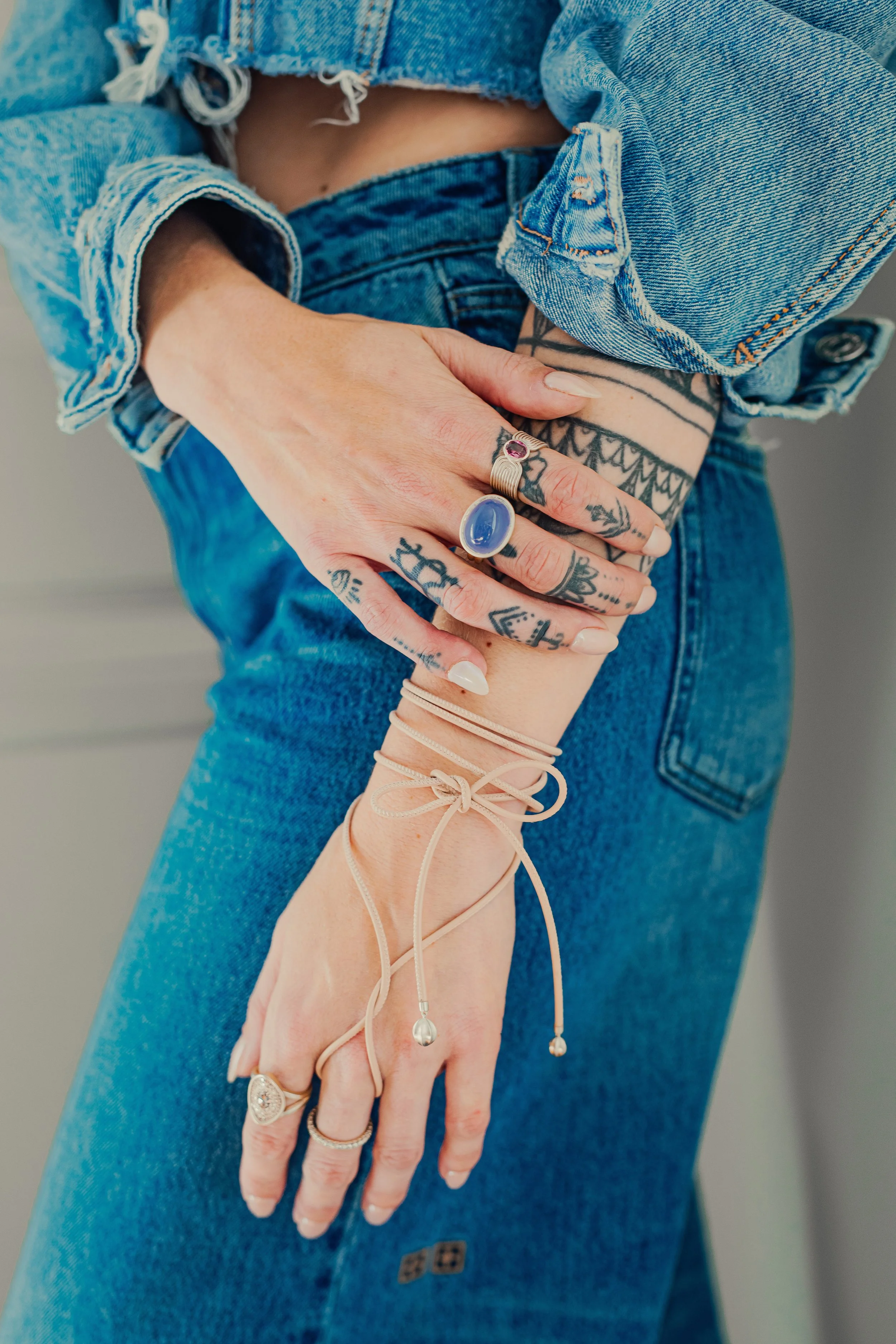 Leigh Maxwell rings in gold with gemstones on models hands