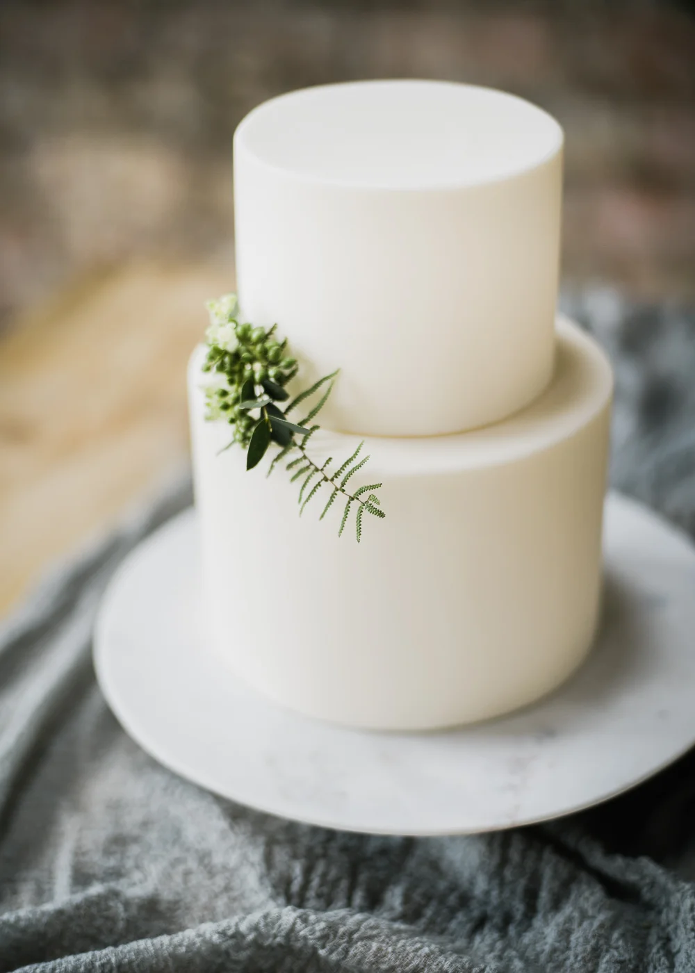 An elegant white wedding cake adorned with foliage.