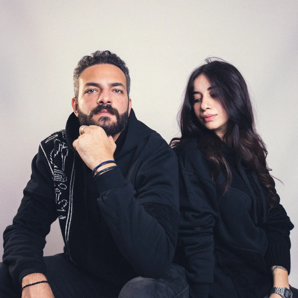 Two people in black, one wearing the Hieroglyphs Black Hoodie