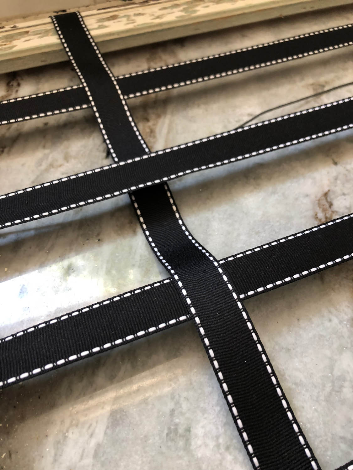 weaving ribbon vertically through horizontal ribbons on frame