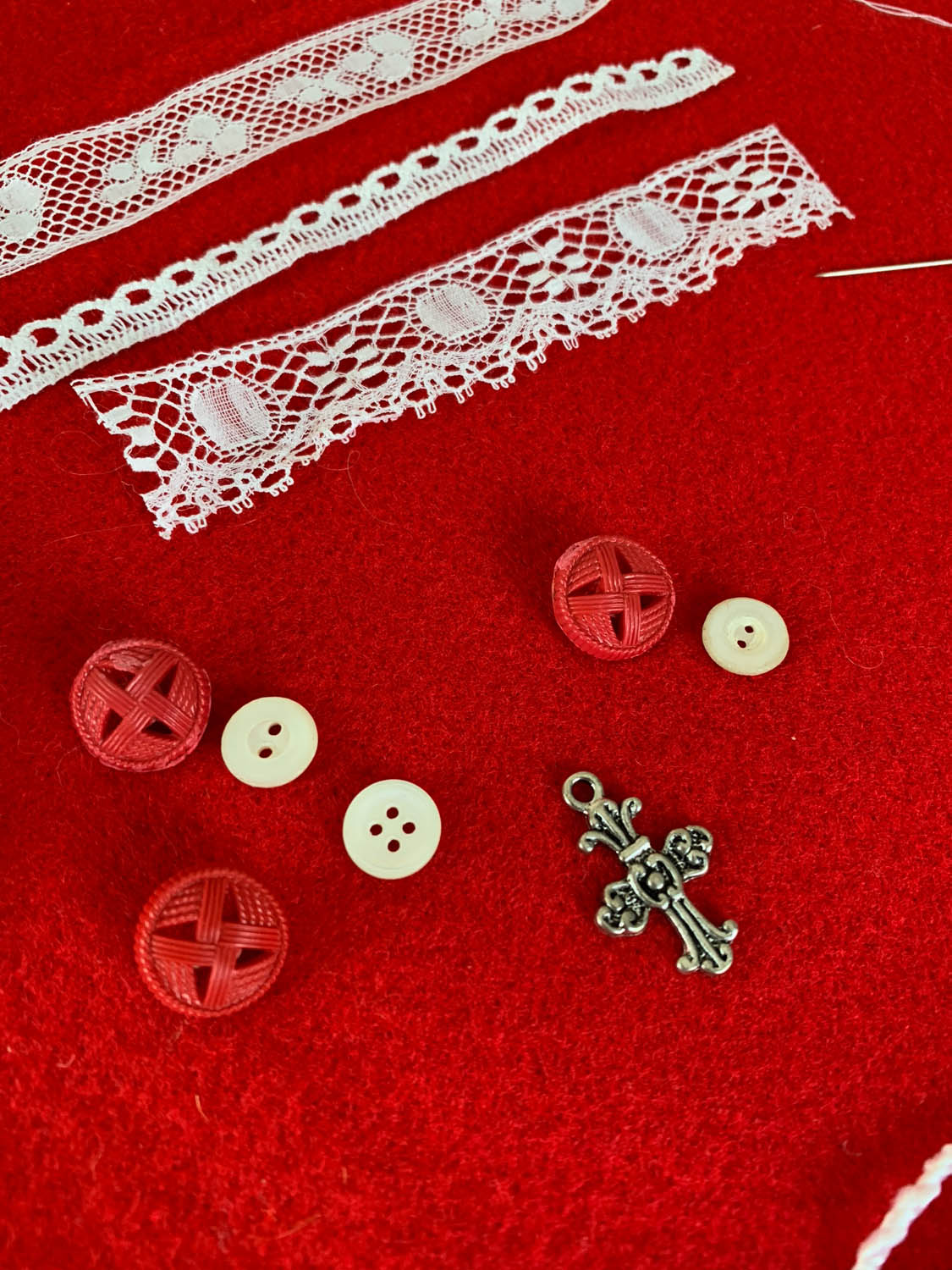 lace trims, buttons and charms atop red felt