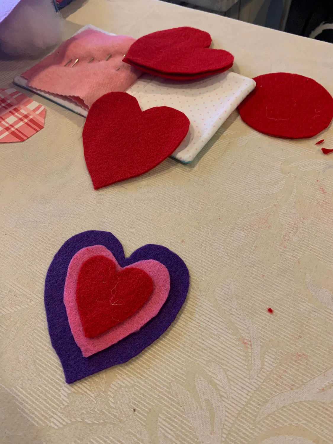 layered felt heart shapes in red pink and purple with a needlebook
