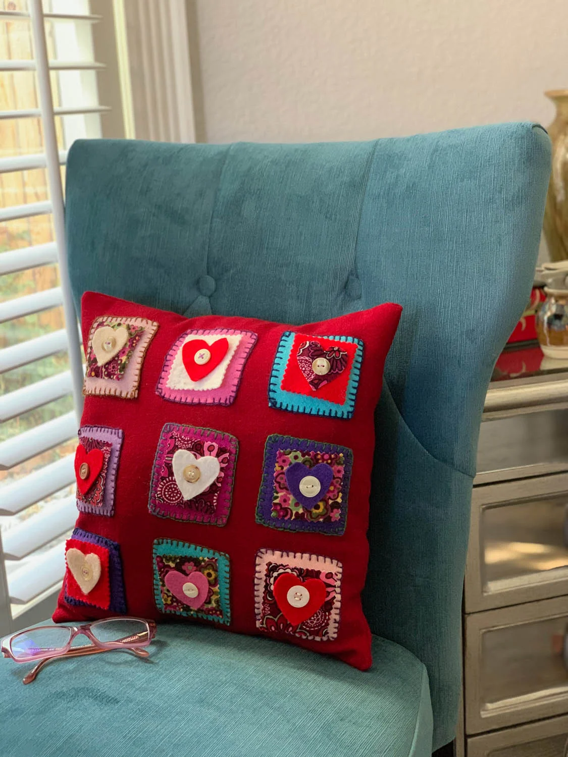 Folksy Felted Valentine’s Day hand embroidered nine-patch hearts pillow in red and vibrant colors.