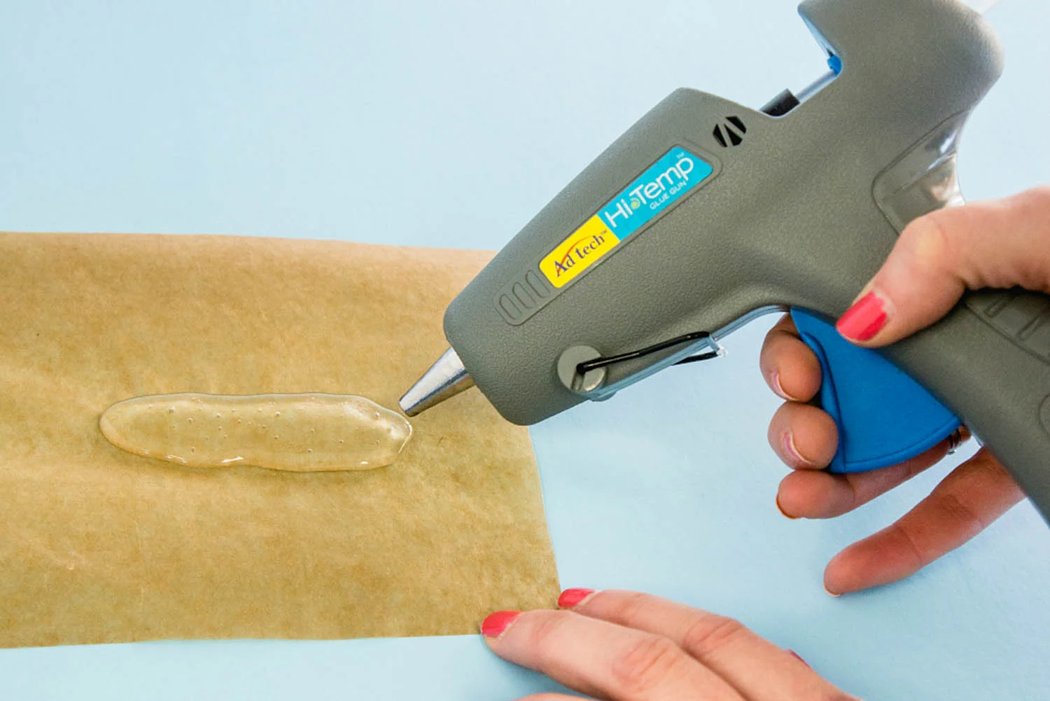 squeezing hot glue onto parchment paper in organic sea glass shape