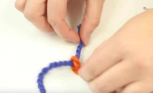 Bringing tail of new yarn through loop of ending yarn
