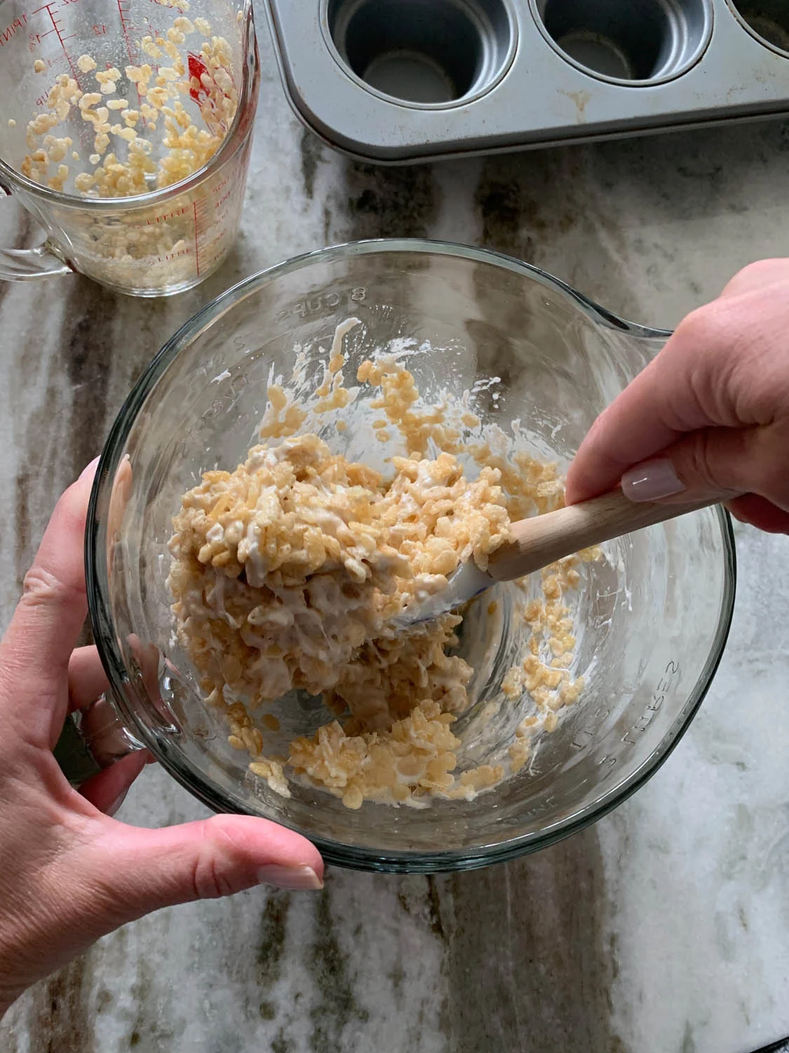 Stirring Rice Crispies cereal into melted marshmallows