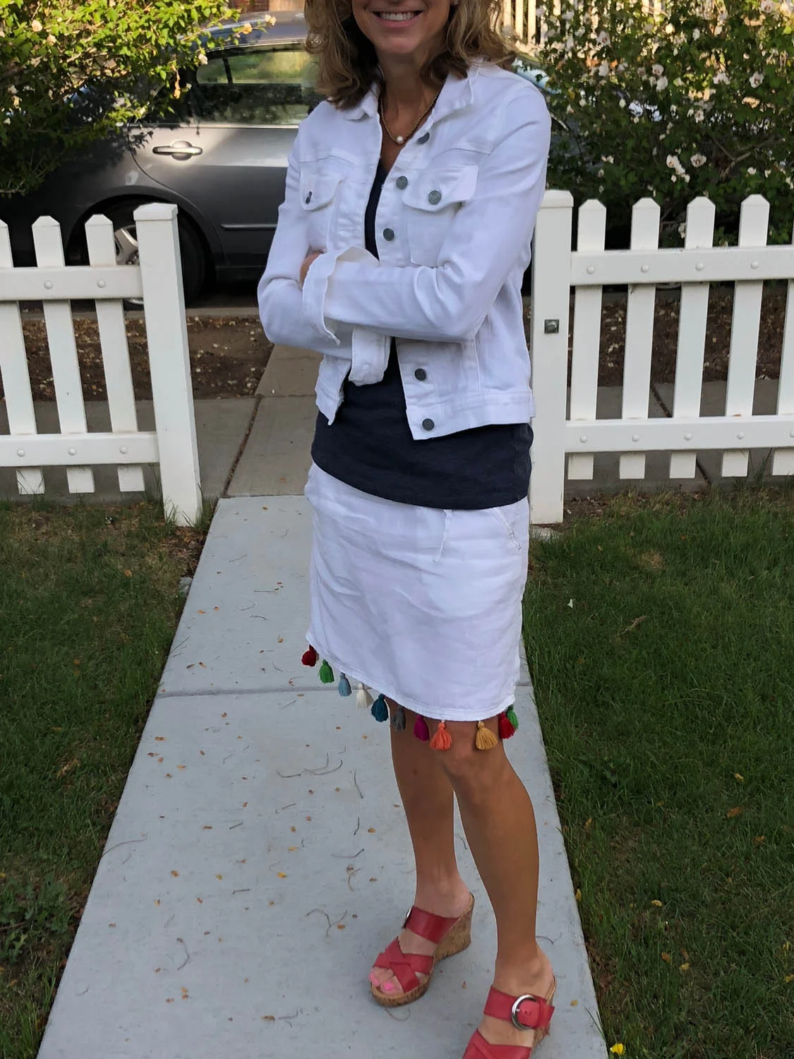 Woman modeling finished white linen skirt embellished with colorful purchased tassel trim.