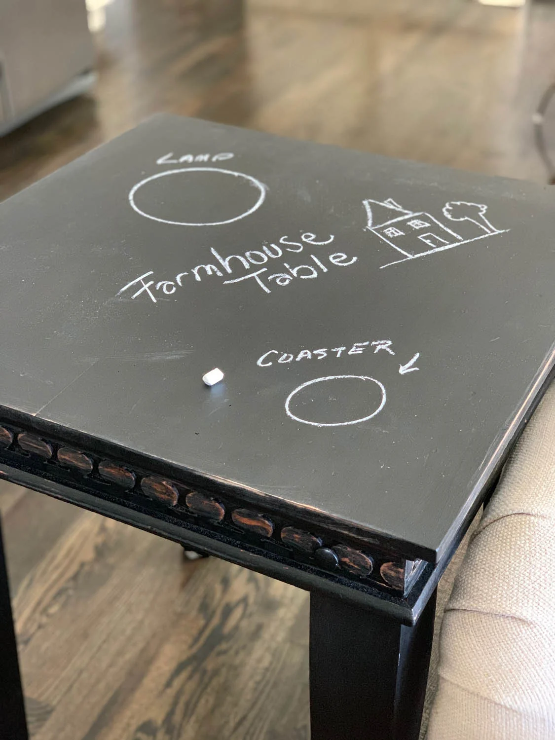 finished thrifty end table upcycle with chalk paint with piece of chalk and writing and drawings on the surface