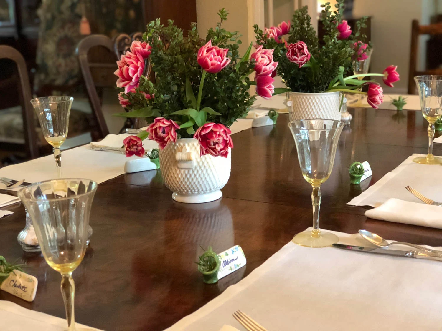 Simple elegant dining table setting with roses, goblets, and linen placemats
