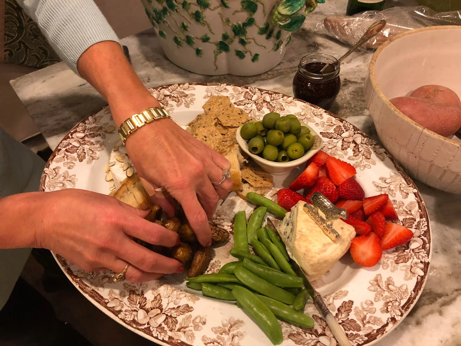 Host’s hands arranging ingredients on hand on a pretty platter for quick and easy appetizers