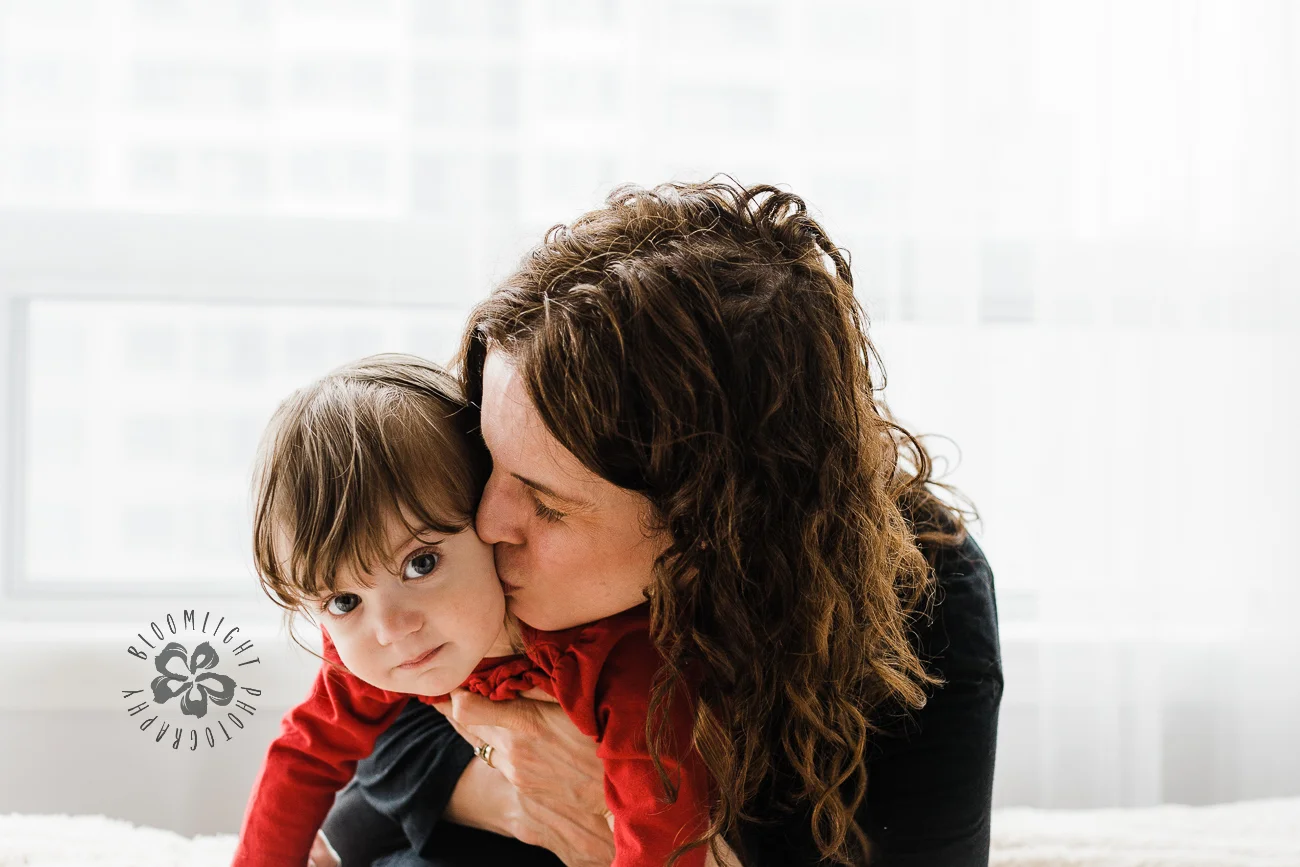 Portrait of mom kissing her baby girl