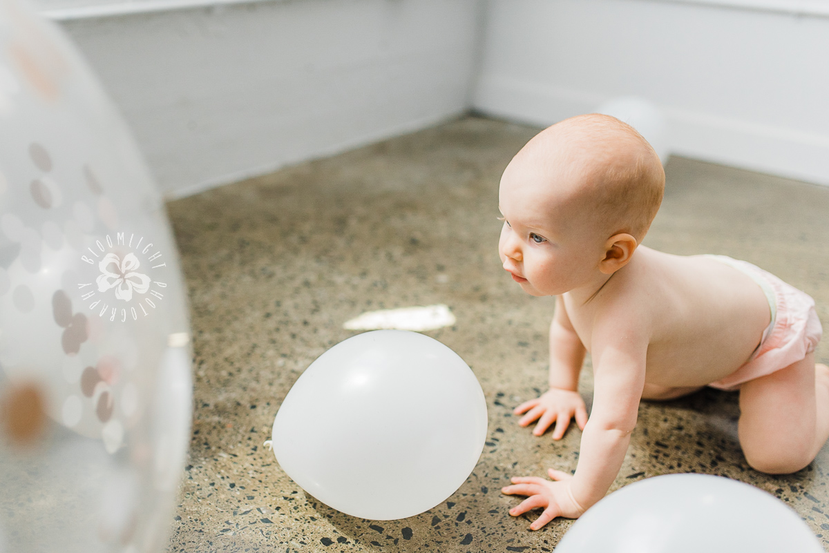 naked baby chasing for balloons in Toronto studio.