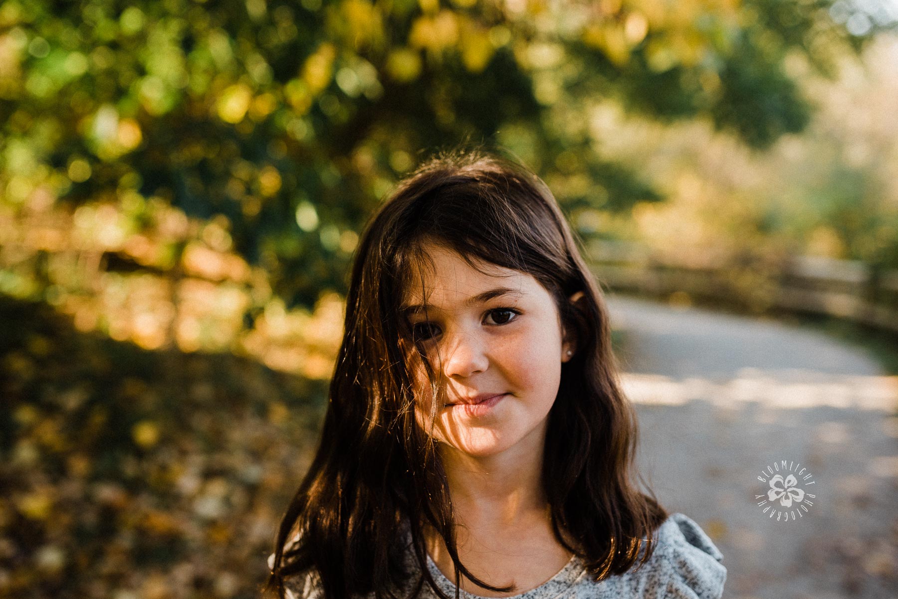 A portrait of cute toddler girl with black hair in a park