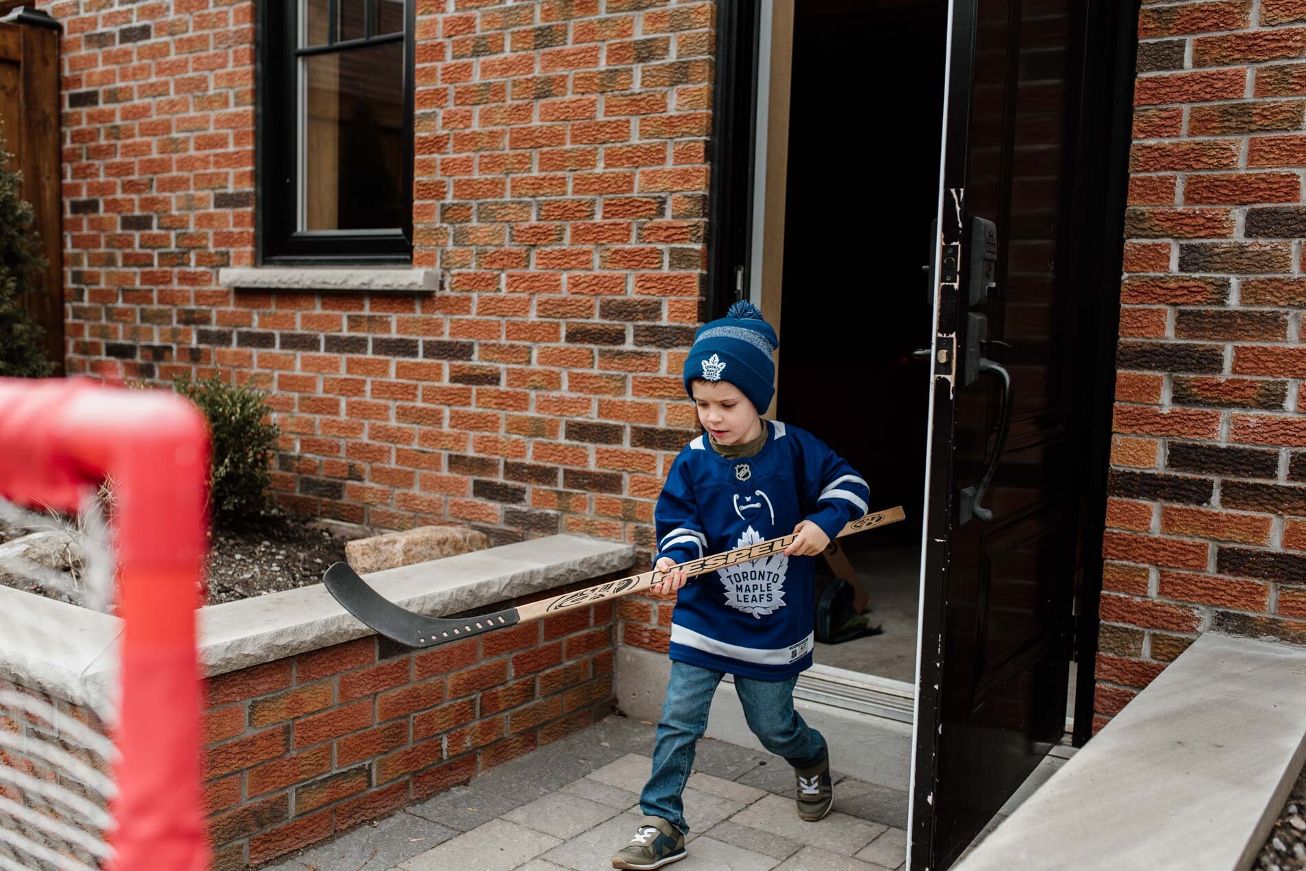 kid is getting ready to play hockey in the backyard, Toronto