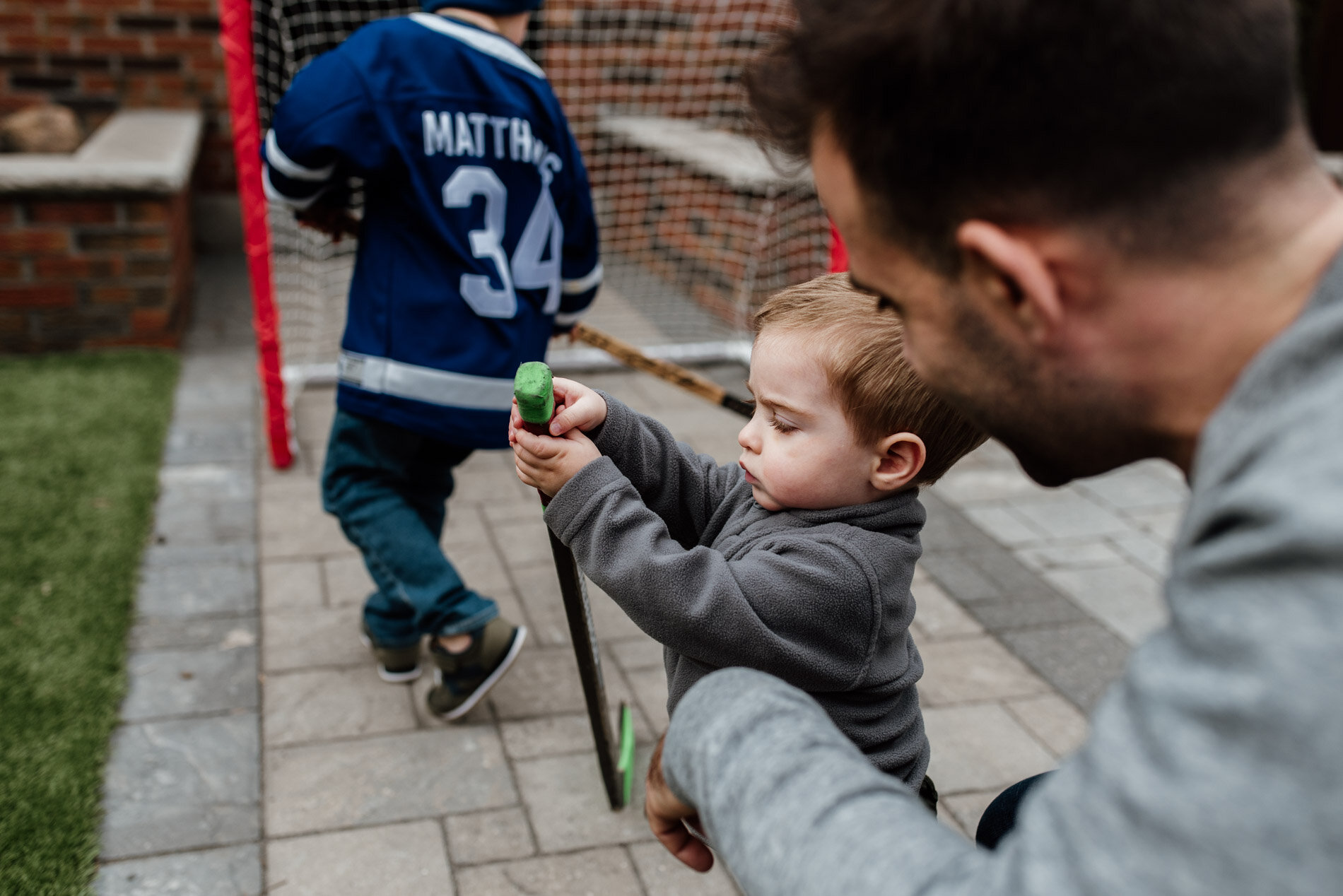 baby boy playing with hockey stick