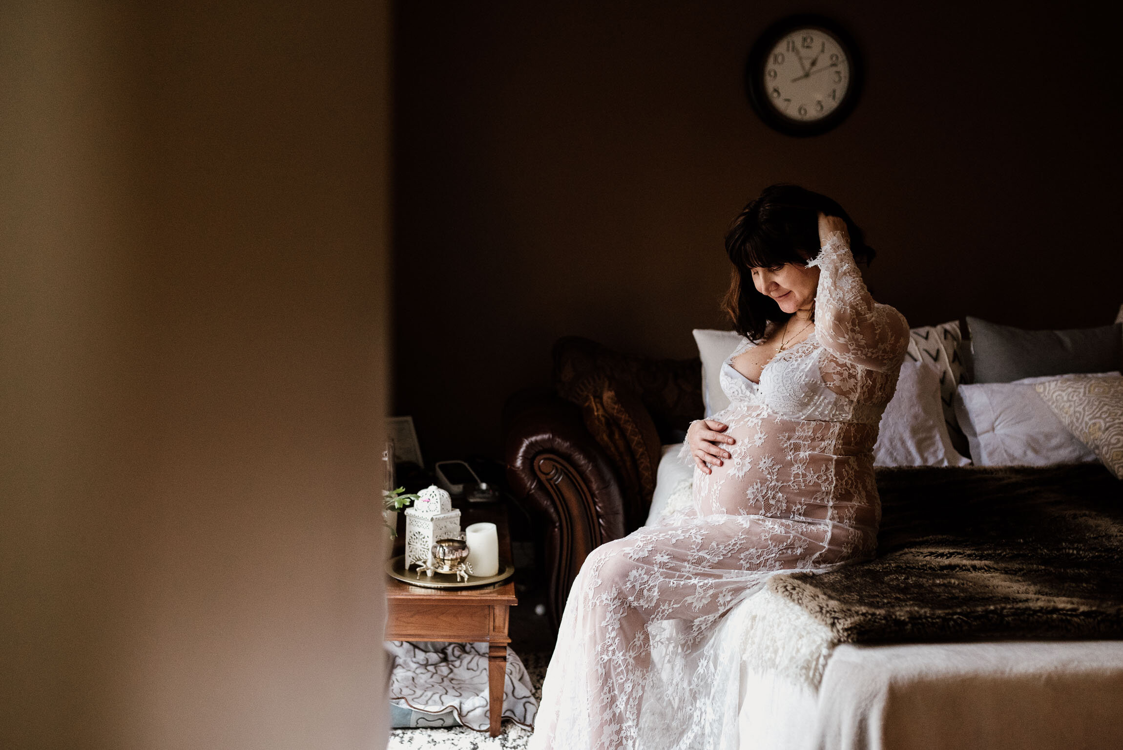 Photo of beautiful pregnant mom wearing white lace dress in the bedroom