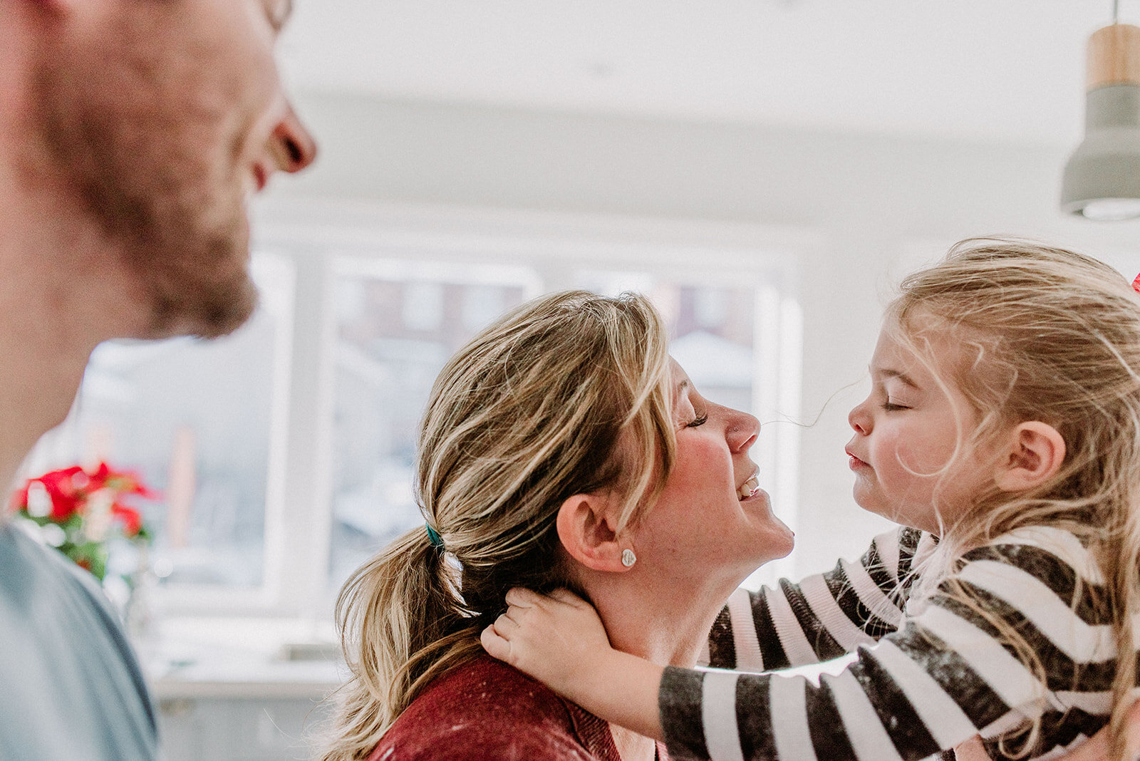 Photo of a toddler girl kissing her mom