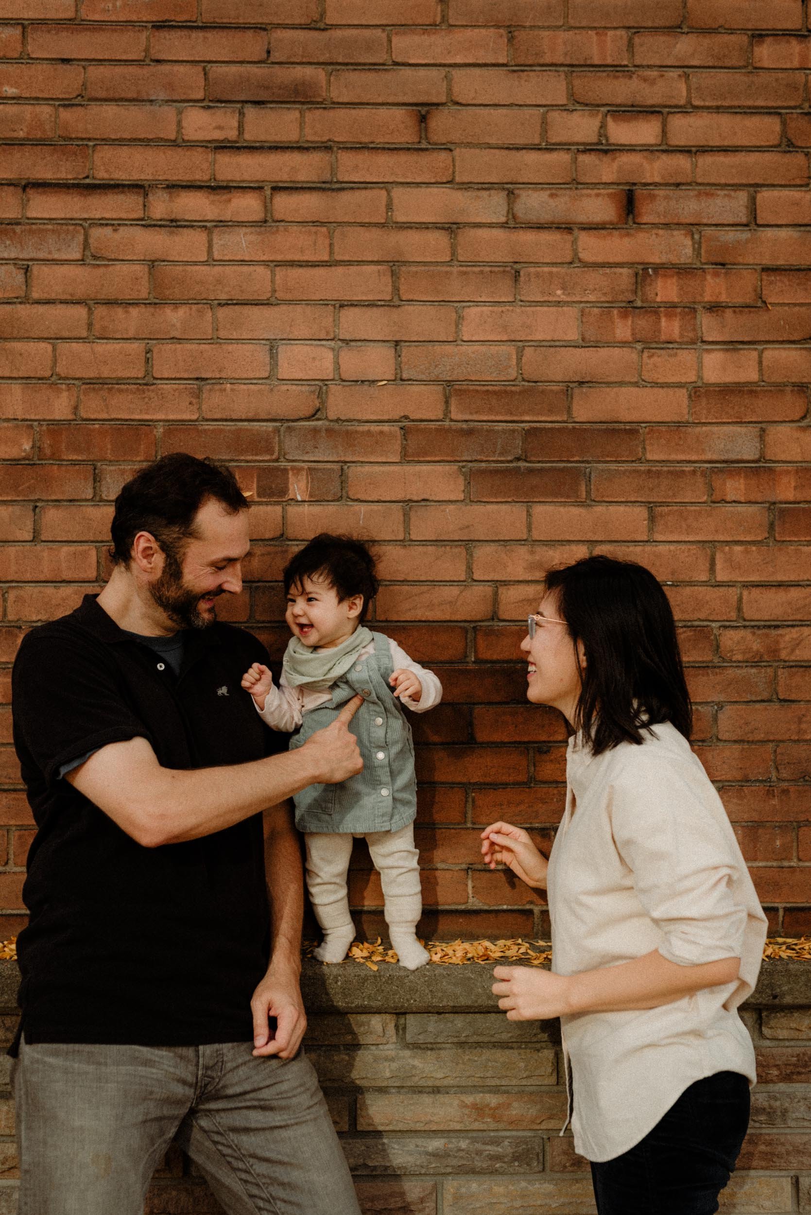 Family laughing with their baby girl in a Toronto neighborhood