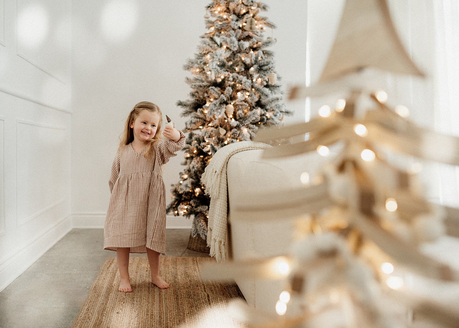 light filled photo of a toddler girl playing during Christmas time