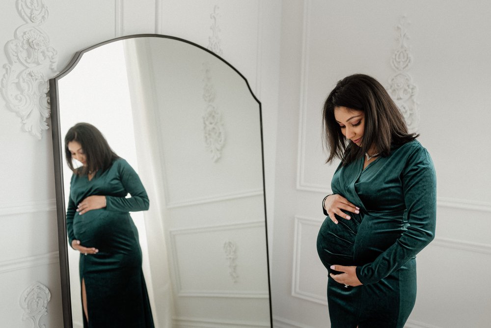 pregnant mama standing in front of mirror 