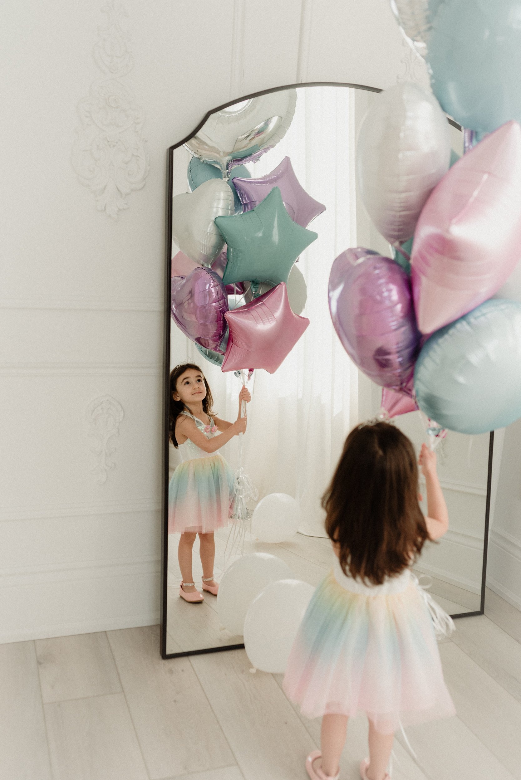 Sweet girl holding her pastel color balloons