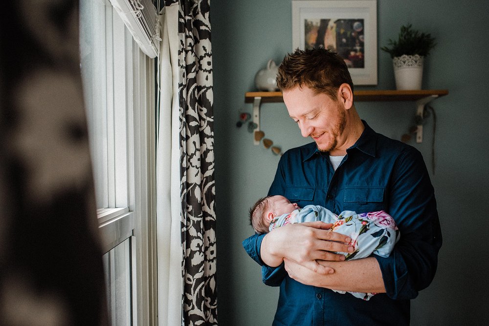 happy daddy cuddling his newborn 