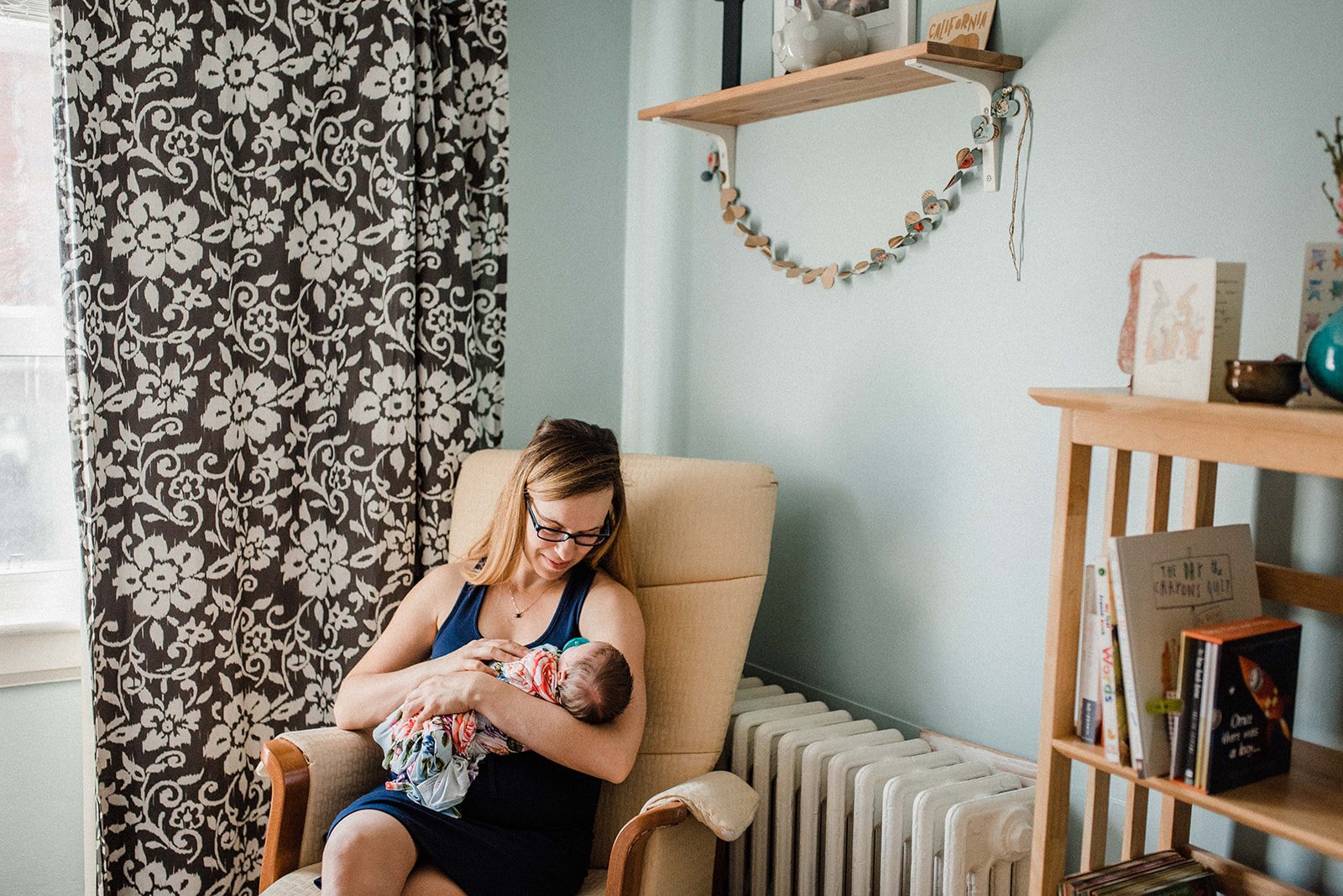 photo of new mom and her baby in the beautiful nursery in Toronto