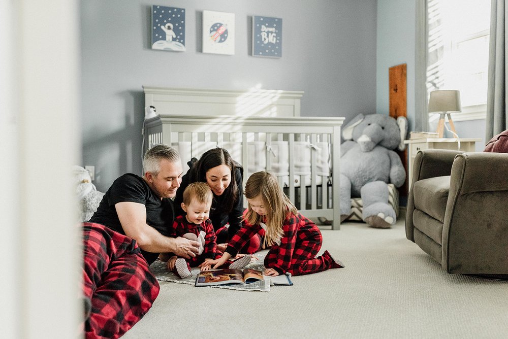 parents reading book for children in the space theme bedroom