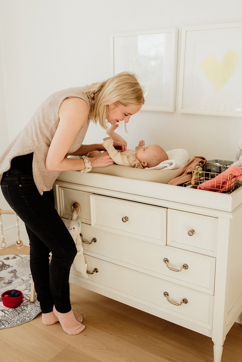 Photo of a mom playing with her baby while changing her in Toronto