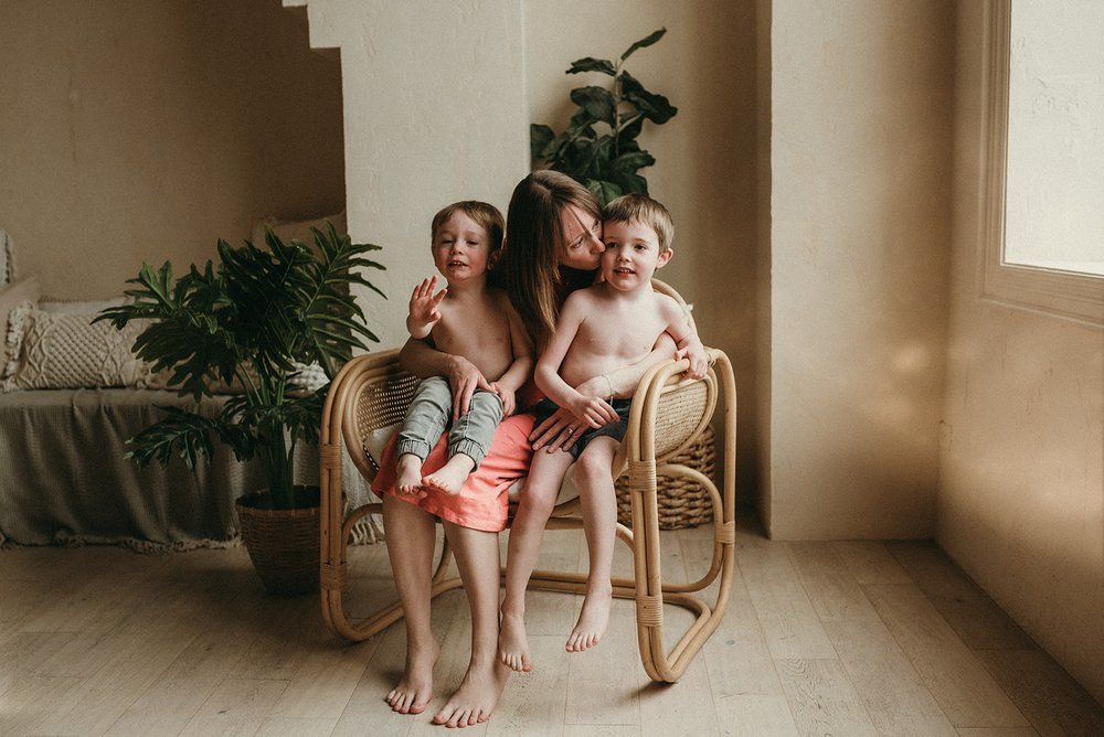 beautiful dreamy picture of a pregnant mom and her sons in Toronto Mint room studios