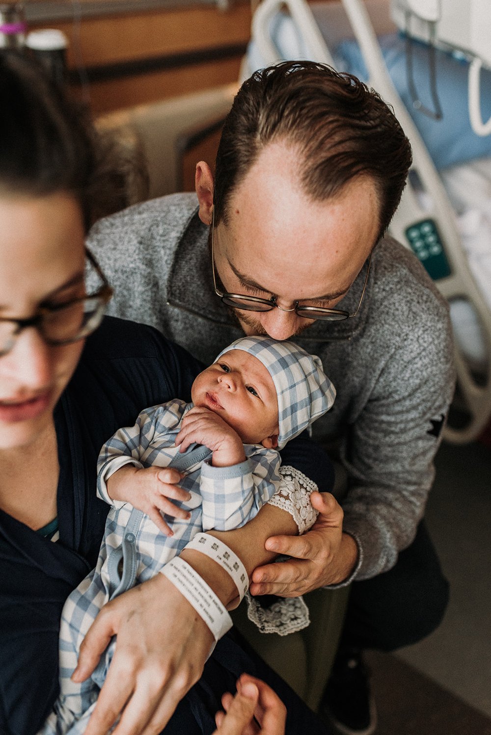 New daddy kissing his newborn in the hospital just one day after birth