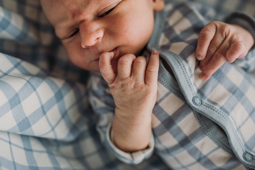 close-up photo of newborn fingers and face