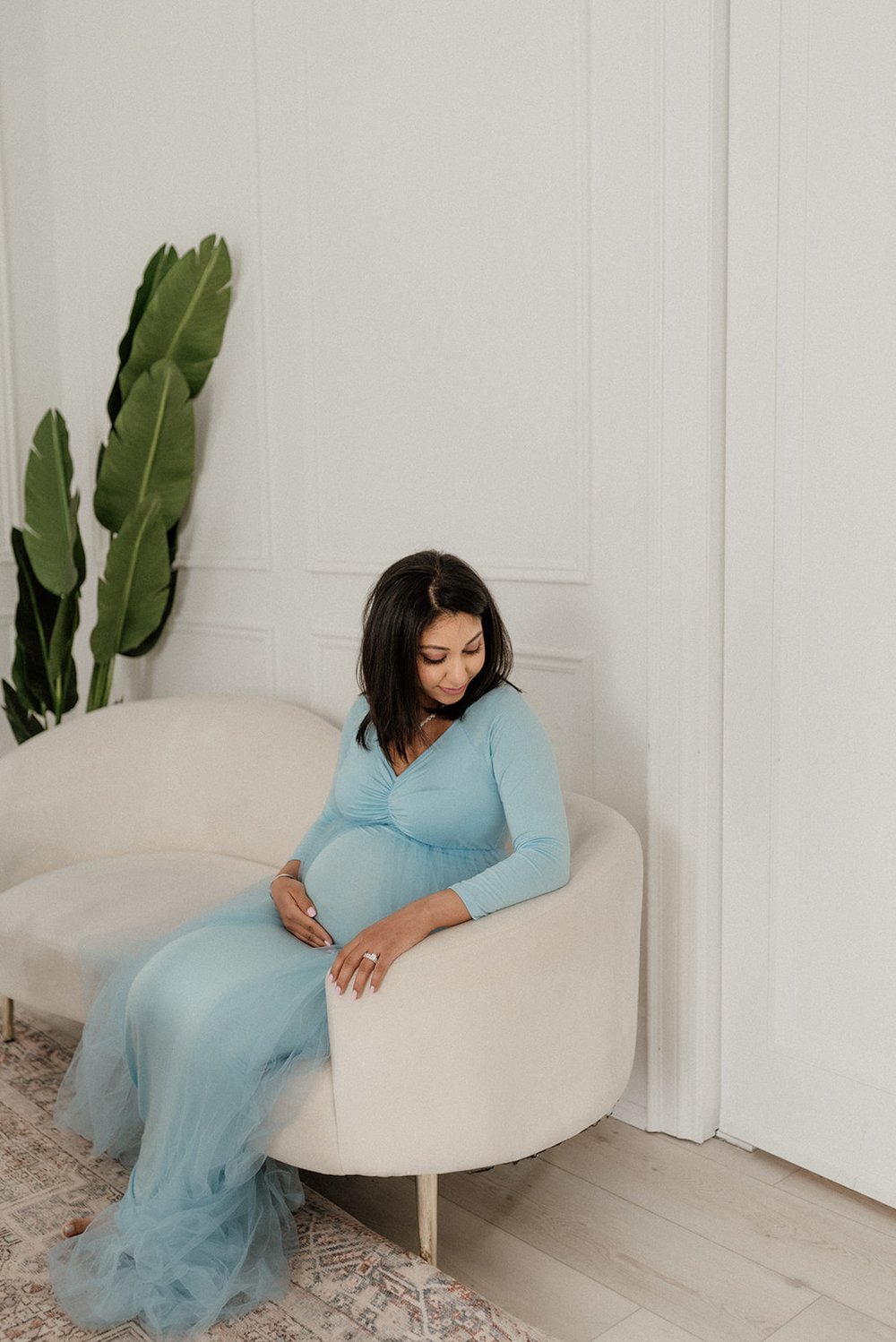 lovely pregnant mom sitting in the couch in studio, Toronto