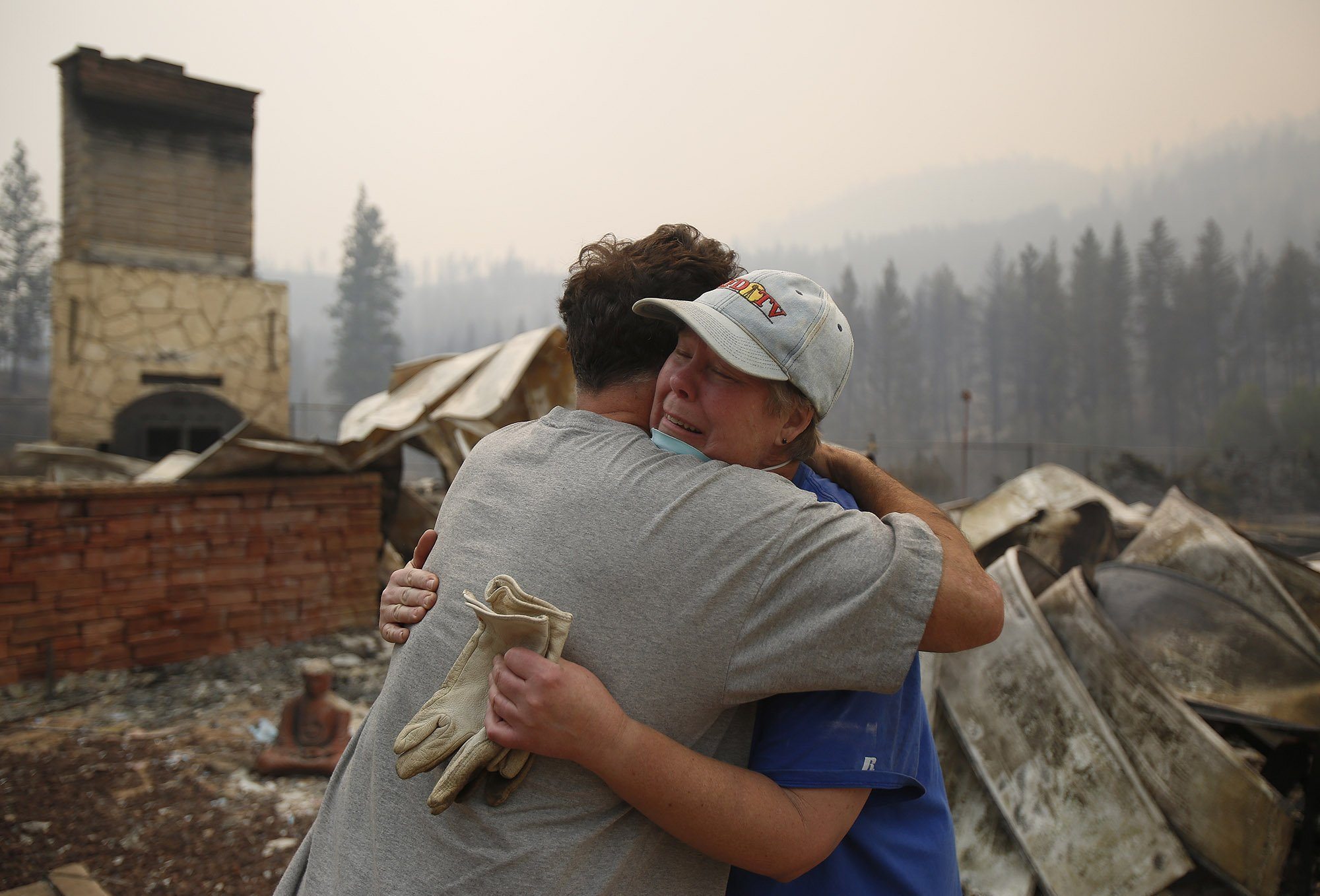  Cindy Aston hugs her neighbor, Todd Quinn, after she lost her childhood home from the firestorm on Saturday, Aug. 15, 2015. 