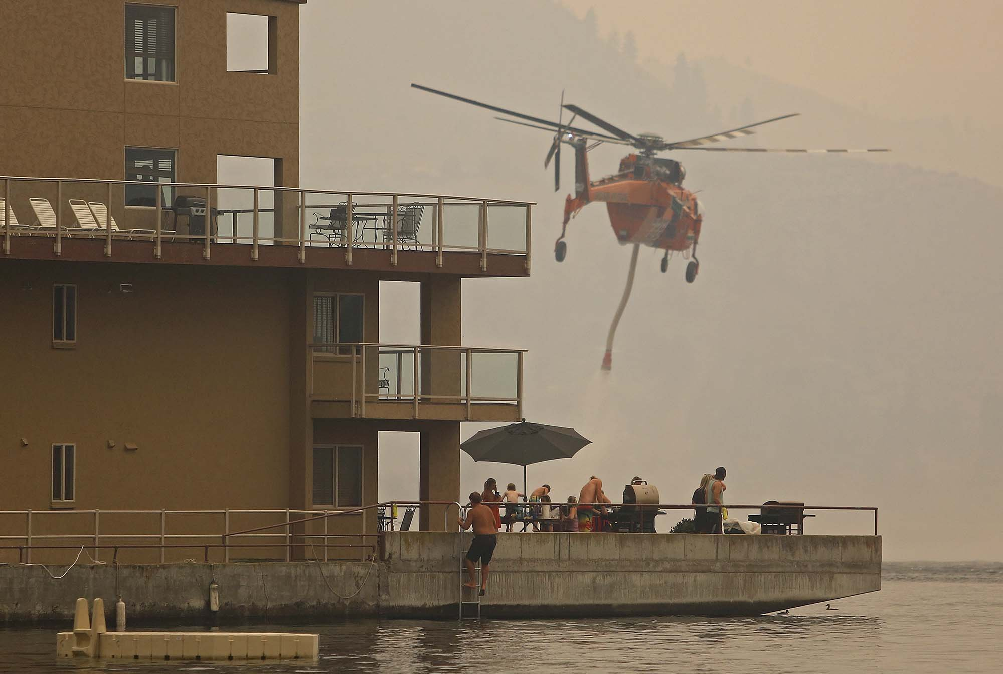  An Erickson Air Crane loads up water on Lake Chelan in as guests at the Grandview On the Lake barbecue, Saturday, Aug. 15, 2015, in Chelan, Wash. 