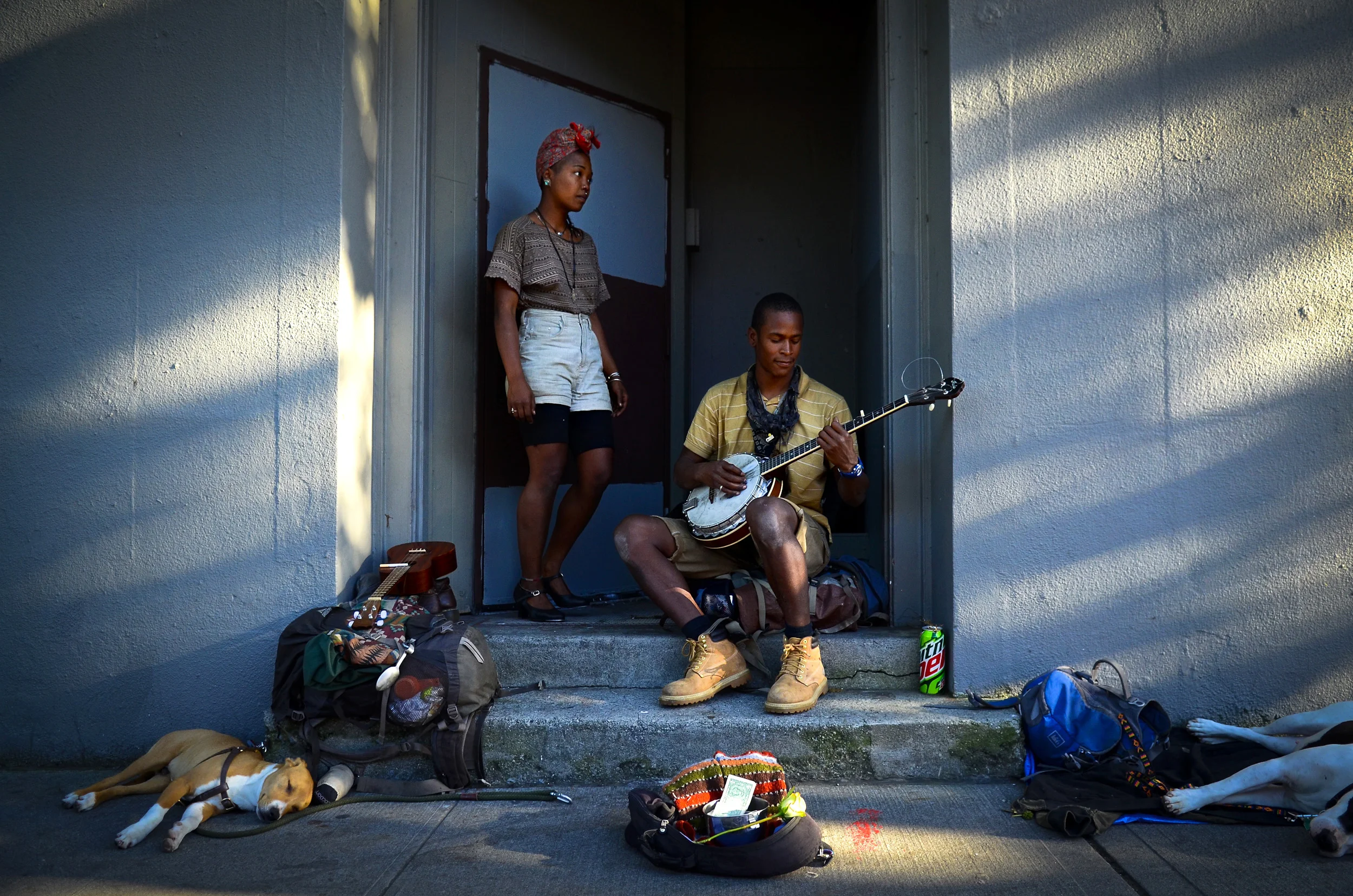 Kiana Daniels and Yoany Carrion busk outside the 2013 Capitol Hill Block Party near the corner of Pike and Broadway, Friday, July 26, 2013. The street musicians recently traveled to Seattle from Montana, and plan on staying in the City for a few more weeks. (Sy Bean / SeattlePI.com)