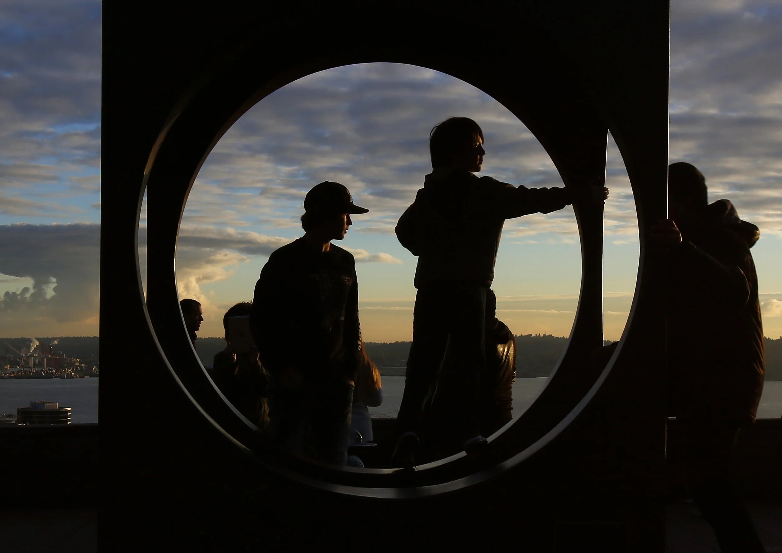  (Left to right) Native Texan, Kamron Luhn, 15, and Nathan Brannan, 9, stand inside "Changing Form," a sculpture by Doris Chase, while gazing over the Puget Sound as the sun sets at Kerry Park in the Queen Anne neighborhood in Seattle, Saturday, Dece