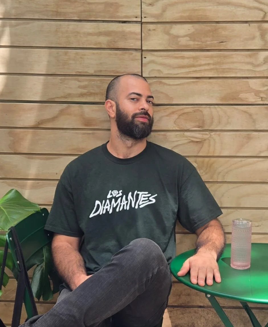 Young man sits at coffee shop with drink on table