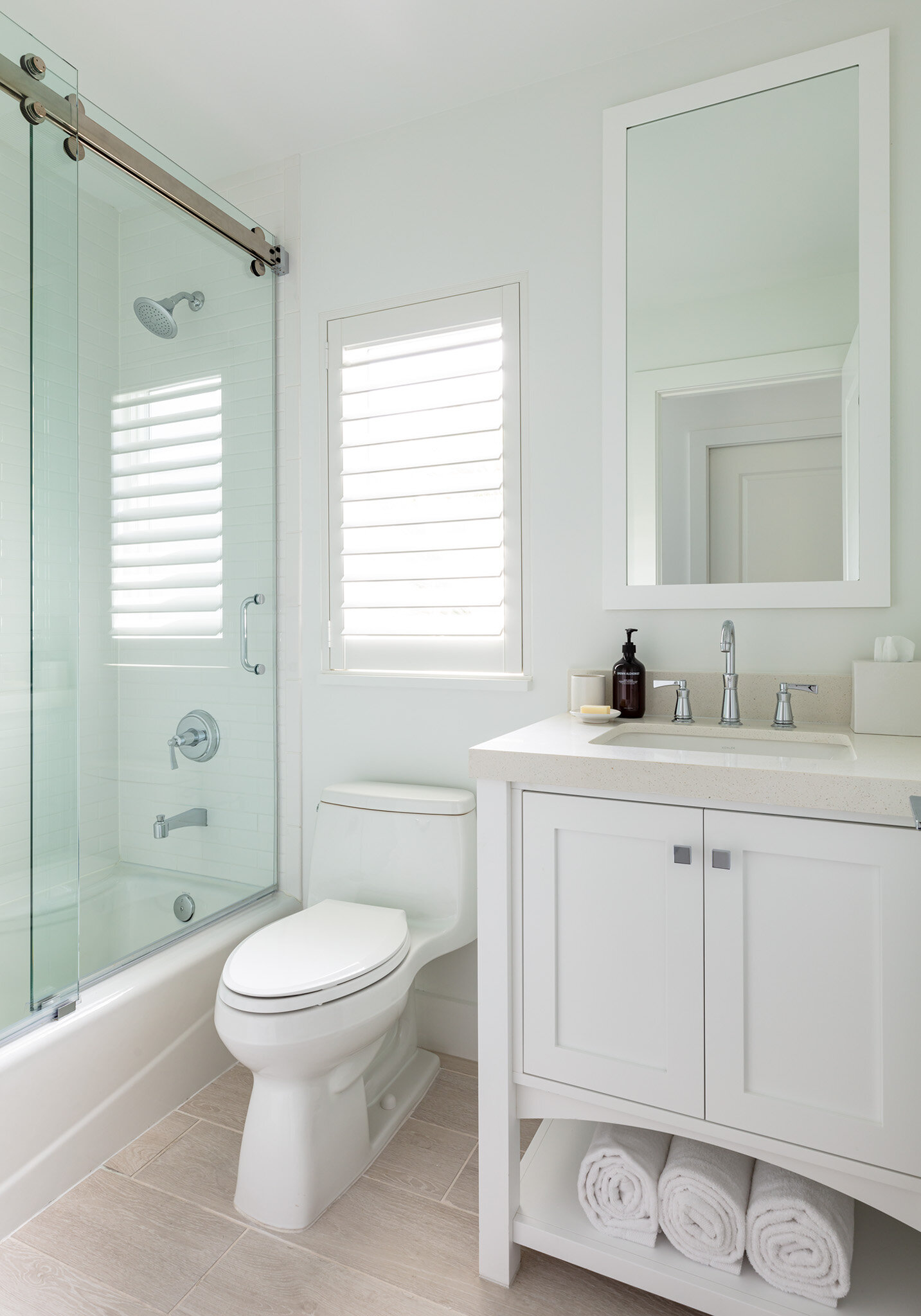  Small bathroom with sink , toilet, and bathtub with sliding glass door in an Islands waterfront villa. 