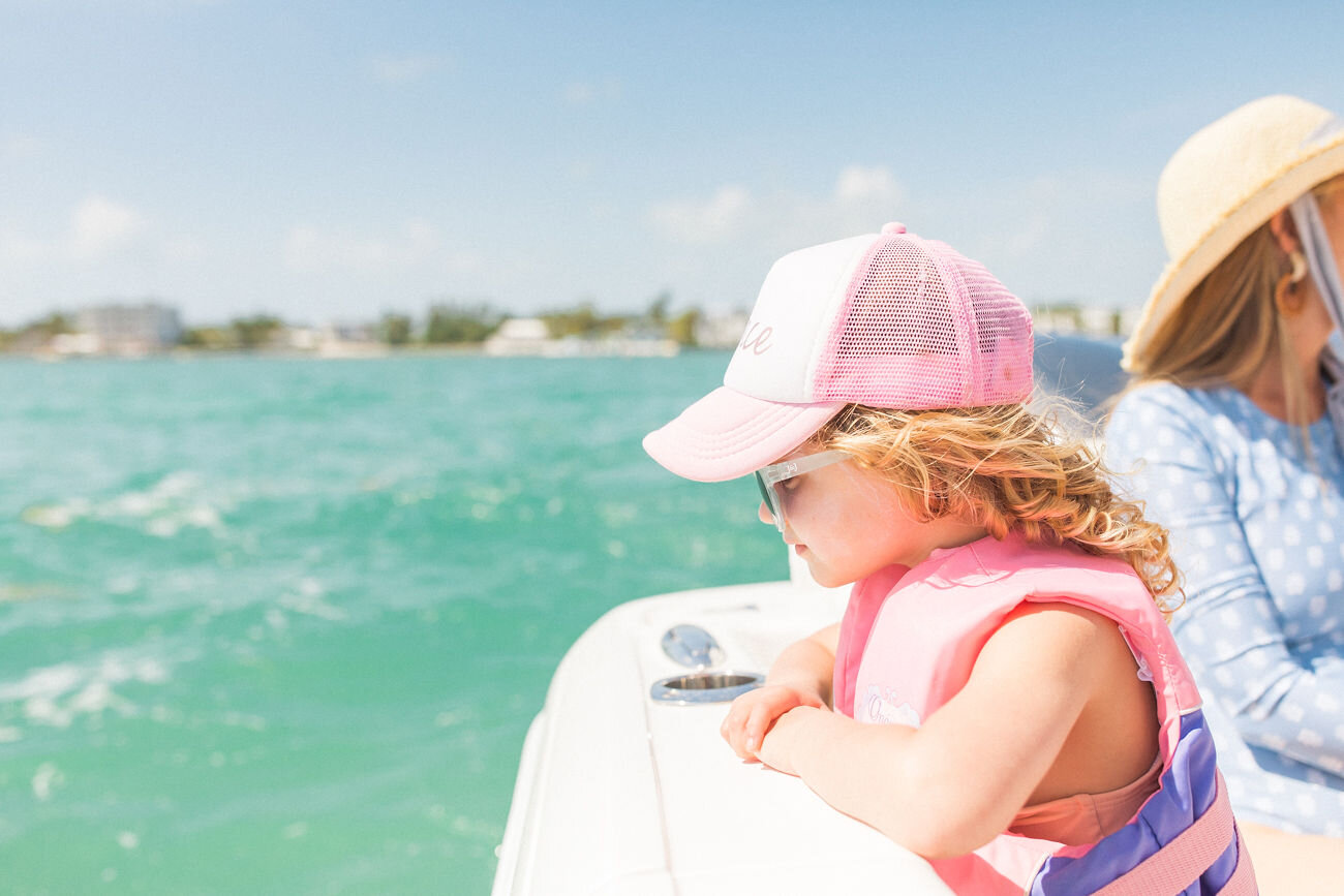  Young girl in a life jacket looks off the side of a boat into the crystal clear waters of the Atlantic Ocean off The Islands of Islamorada’s private beach. 