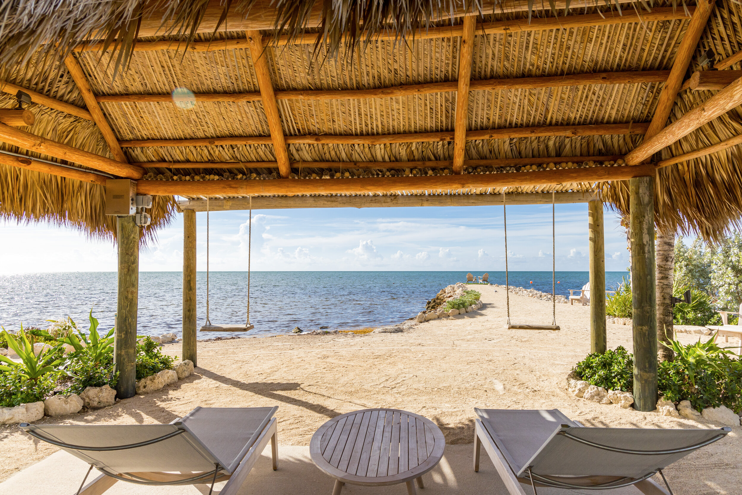  Swings and lounge chairs under The Islands of Islamorada’s beachside tiki bar hut. 