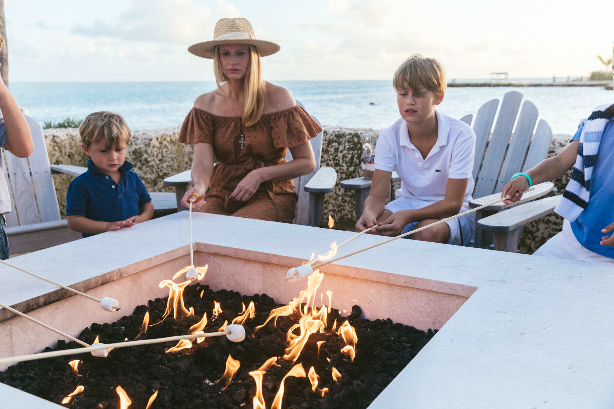  Mother And Her Young Sons Roast Marshmallows Over The Islands Of Islamorada’s Beachside Fire Pit While On A Beach Vacation In Florida. 