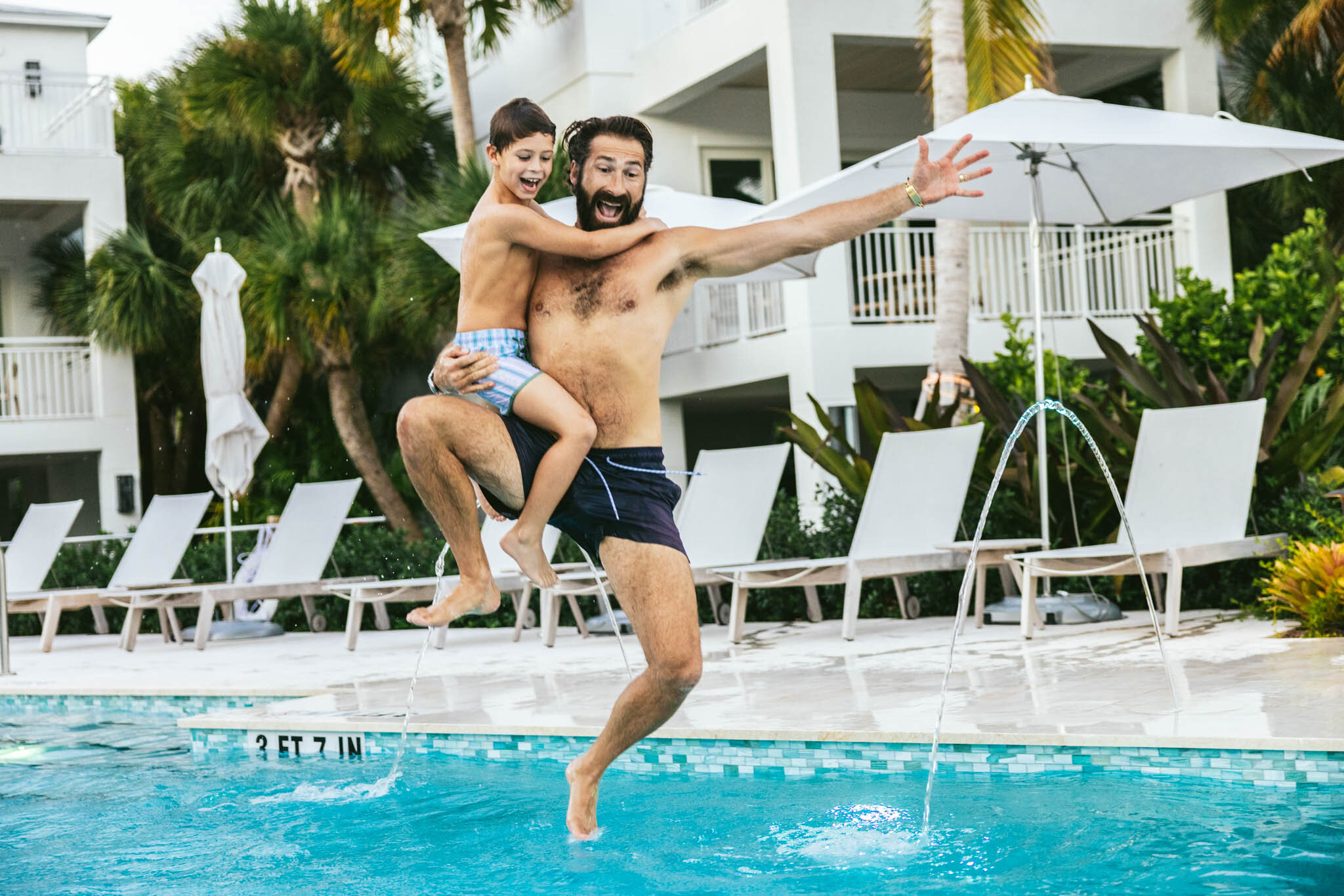  A father holds his son as they both jump into The Islands of Islamorada’s private pool. 