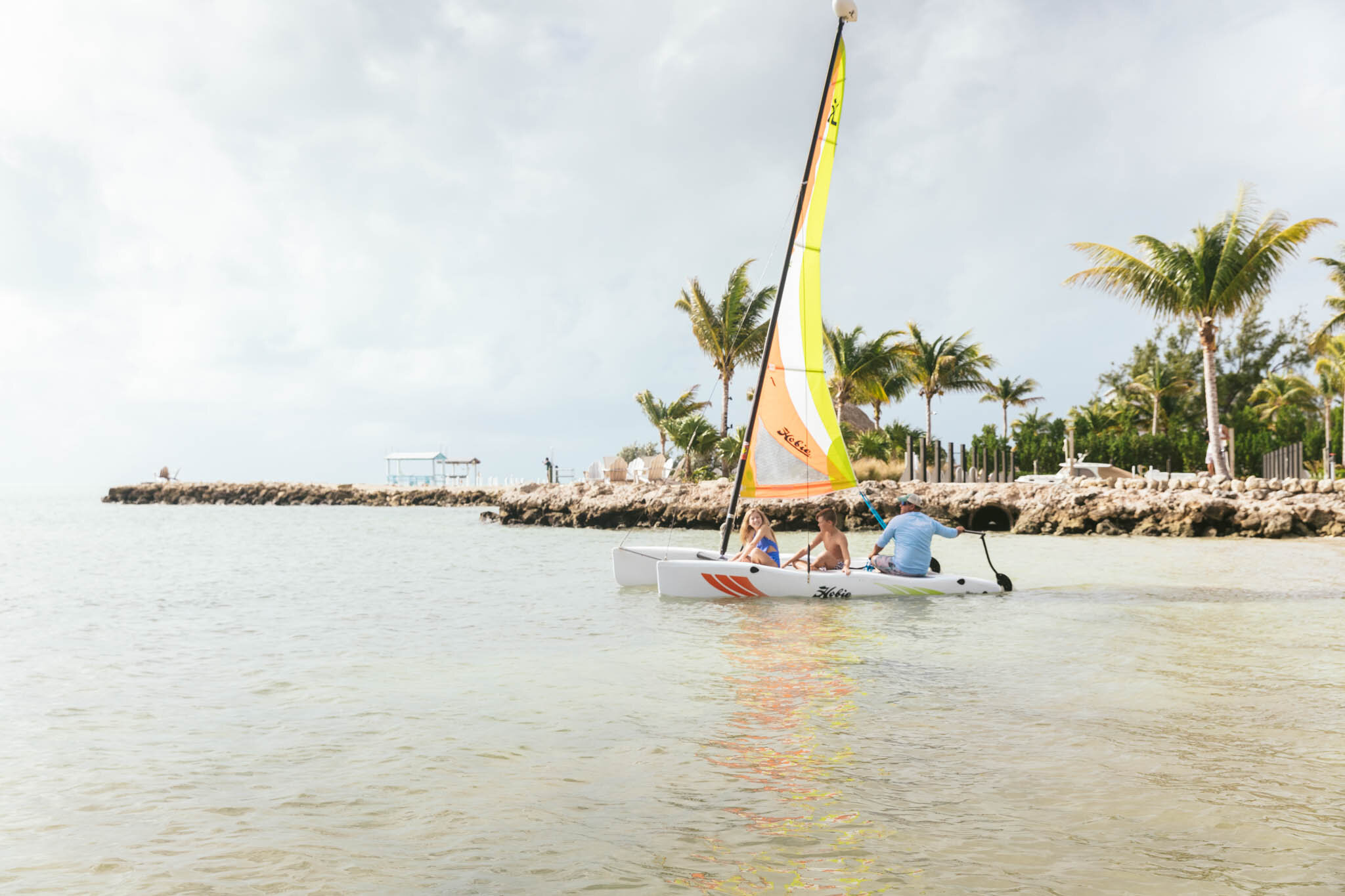  Father And Two Kids On Their Florida Vacation Set Out On A Sailboat From The Islands Of Islamorada’s Private Beach. 
